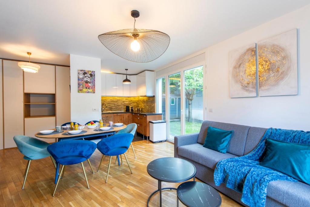 a living room with a couch and a table and chairs at Stunning 3Bedroom Apartment with Garden in Prestigious Area I Eiffel Tower Within 15 Minutes' Drive in Issy-les-Moulineaux