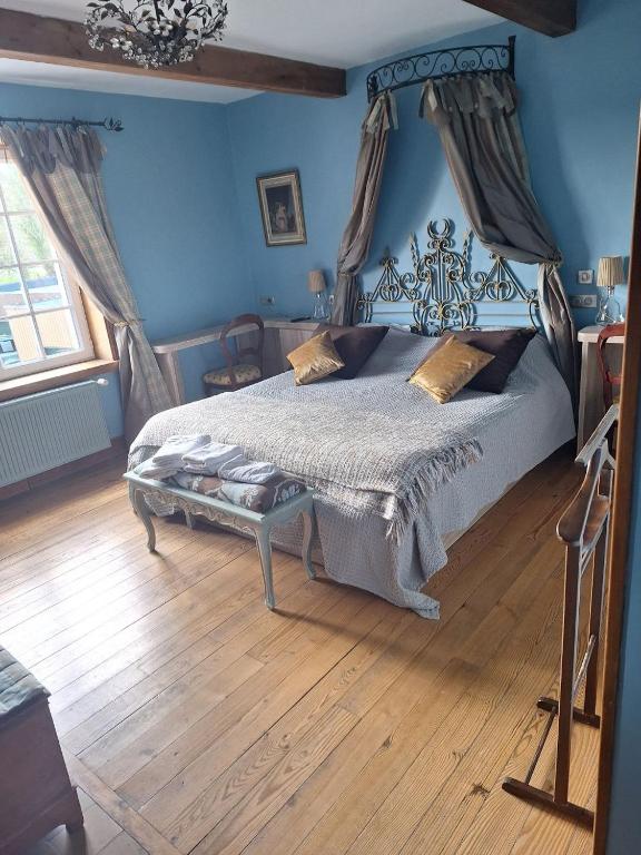 une chambre avec un lit dans une pièce bleue dans l'établissement Le clos de Tournes, à Echinghen