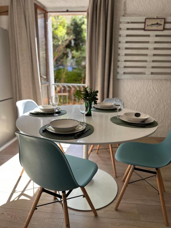 a white table with chairs and plates and glasses on it at Casa Frida in Capraia