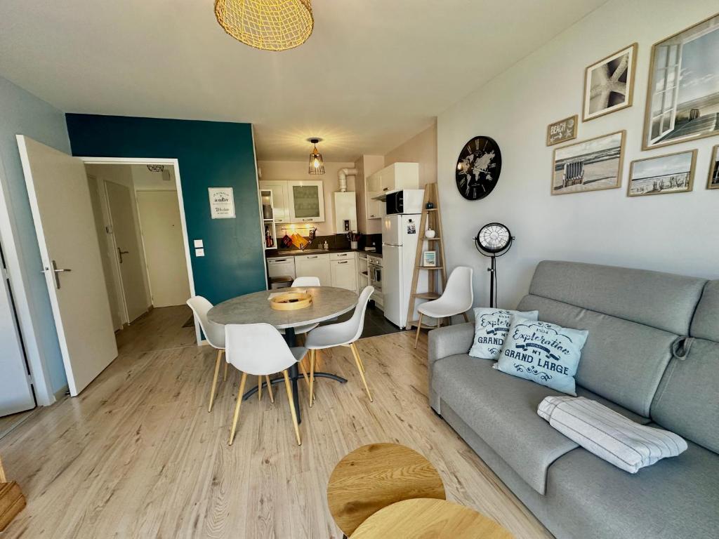 un salon avec un canapé et une table dans l'établissement Le Calme Marin avec jardin à 150m de la plage, à Courseulles-sur-Mer