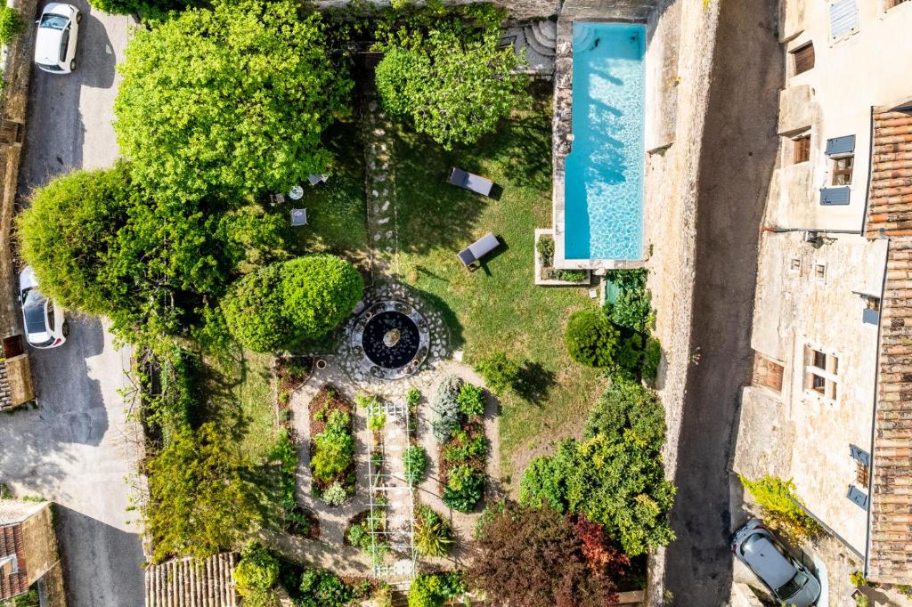 Elle offre une vue sur un jardin avec des arbres et une piscine. dans l'établissement Le Jardin suspendu, à Grignan