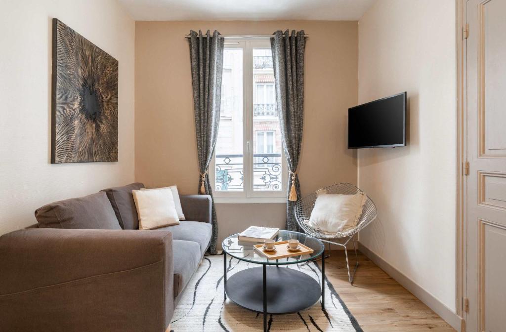 un salon avec un canapé et une table dans l'établissement Apartment near Porte de Versailles, à Paris