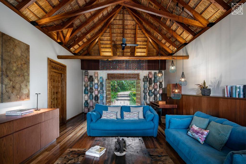 a living room with blue couches and a wooden ceiling at Zuri Zanzibar in Kendwa