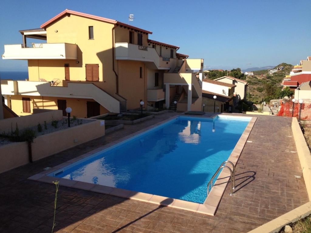 une piscine en face d'un bâtiment dans l'établissement Residence L'Incanto Attici, à Castelsardo