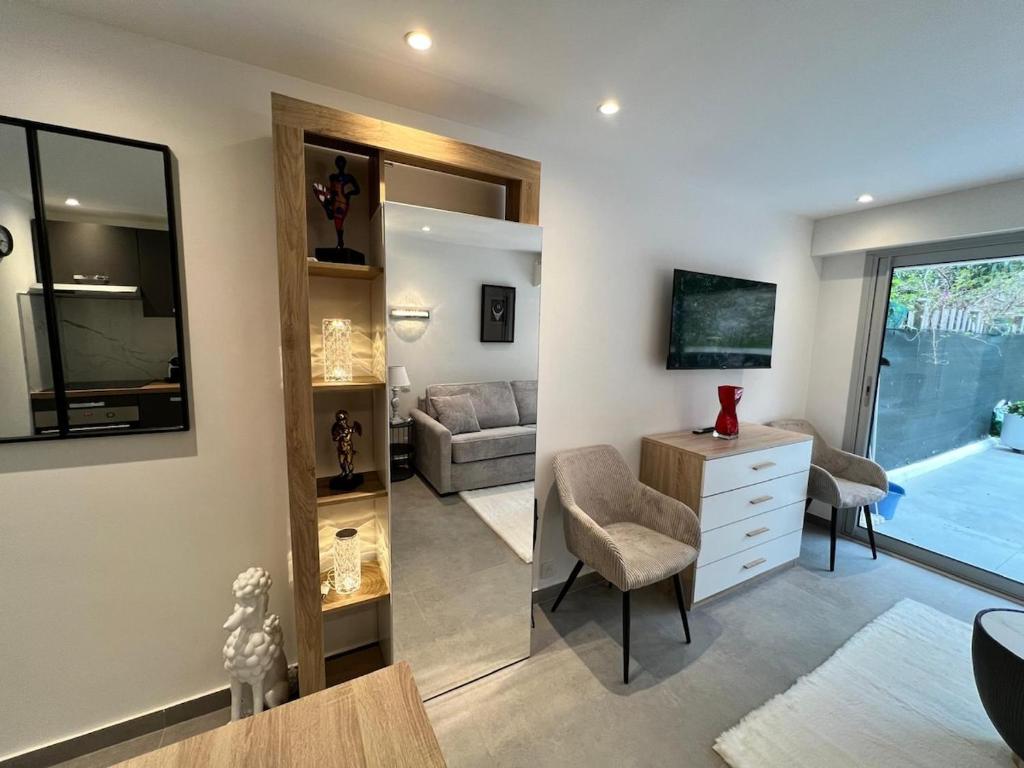 - un salon avec un canapé, une chaise et un miroir dans l'établissement Renovated studio near beach, à Cannes