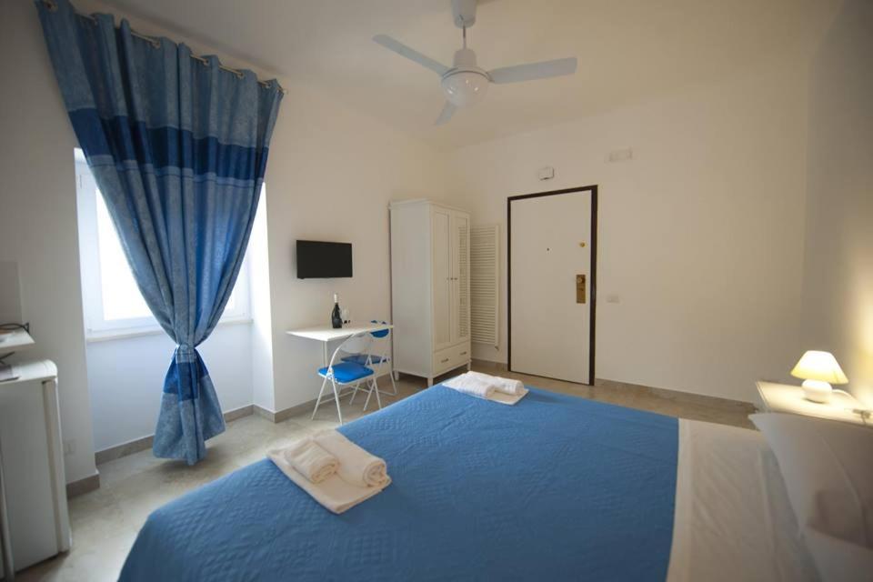 a bedroom with a blue bed and a window at Casale Delle Piane in Matera