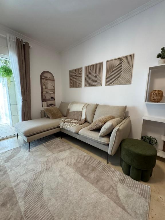 Una sala de estar con un sofá y un taburete verde en Изумительные апартаменты, en Calpe