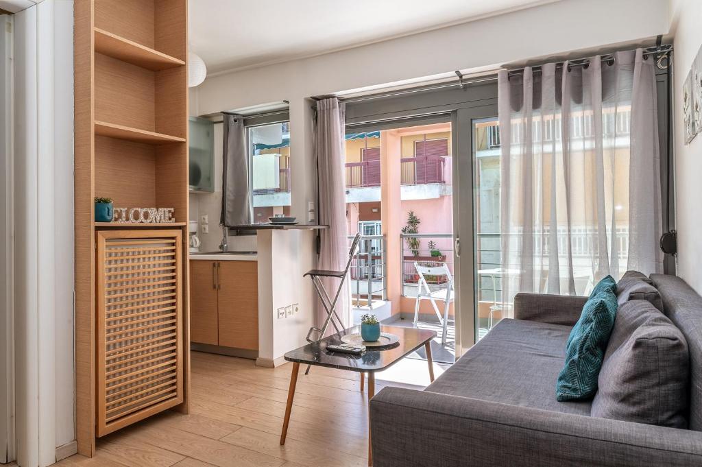 Una sala de estar con un sofá y una cocina. en Elvita Apartments, en Atenas