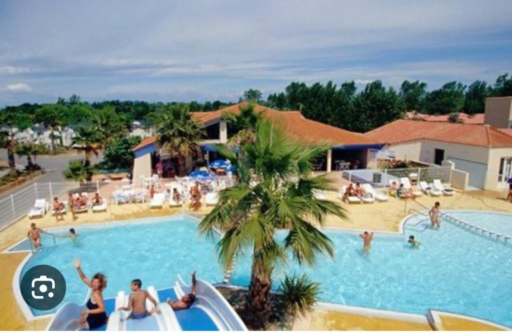 un groupe de personnes dans une piscine d'un complexe hôtelier dans l'établissement Mobile home les sablines, à Vendres-Plage