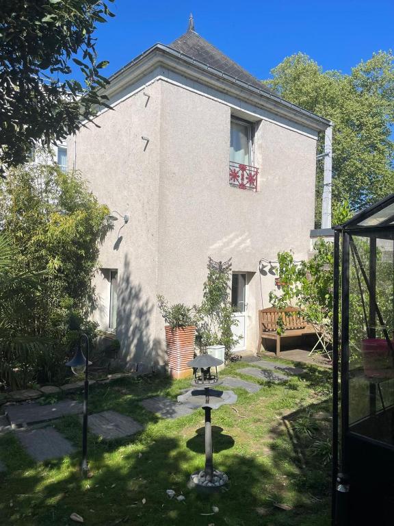 une maison avec une cour dotée d'un barbecue devant elle dans l'établissement Logement entier - Le pigeonnier de la plume, à Nantes