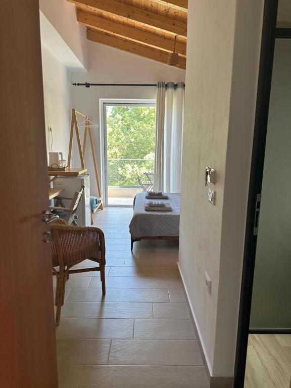 a hallway with a bedroom with a bed and a window at ELÉA Guesthouse himare in Himare