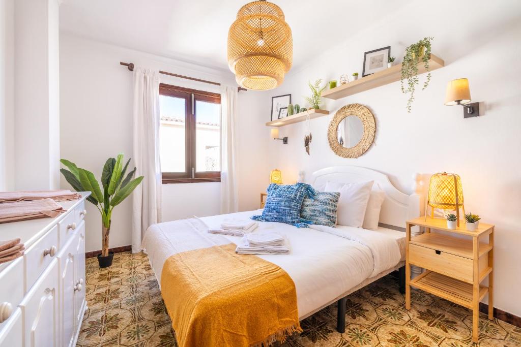 - une chambre blanche avec un lit et une couverture jaune dans l'établissement Porto Cristo 6 persons, à Manacor