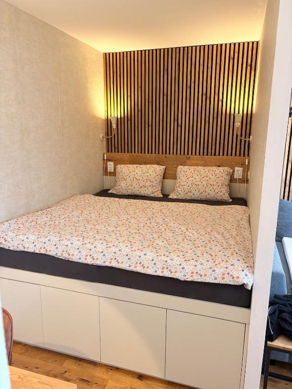 a bedroom with a large bed with a wooden headboard at Harrachov apartment - Moderní horský apartmán v Harrachově pro 2-4 osoby, parkování, lyžárna, kolárna in Harrachov
