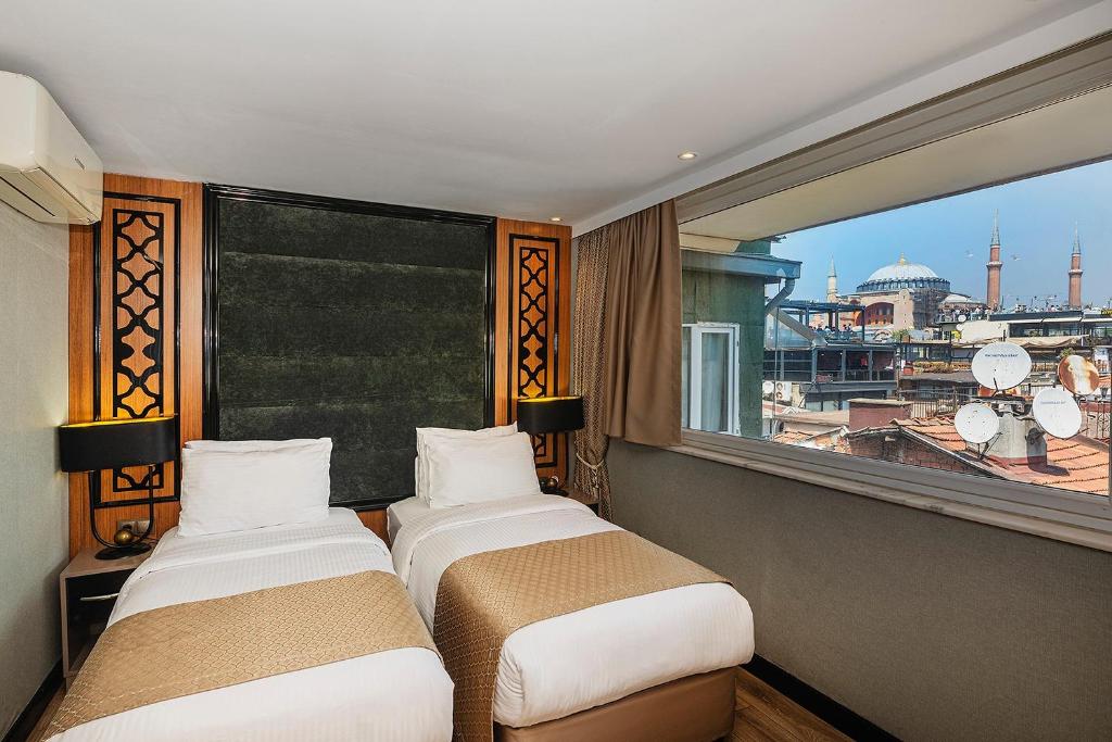 A bed or beds in a room at Aristocrat Hotel