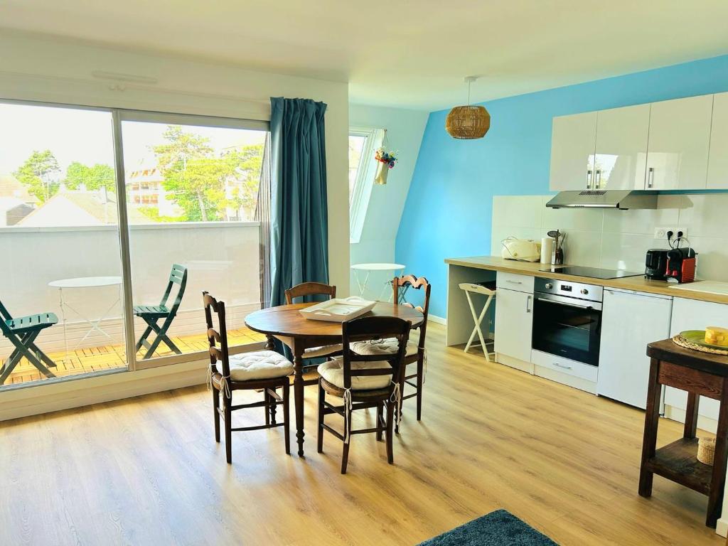 une cuisine et une salle à manger avec une table et des chaises dans l'établissement L'albatros - F2 à Cabourg, à Cabourg