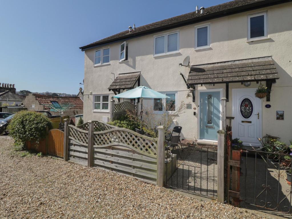 a house with a wooden fence in front of it at Malting Cottage in Dawlish