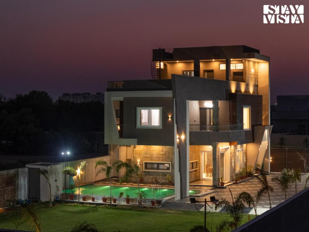 a villa with a swimming pool at night at StayVista at Pinkal Farms with Pool, Lawn, Wi-Fi in Jaipur