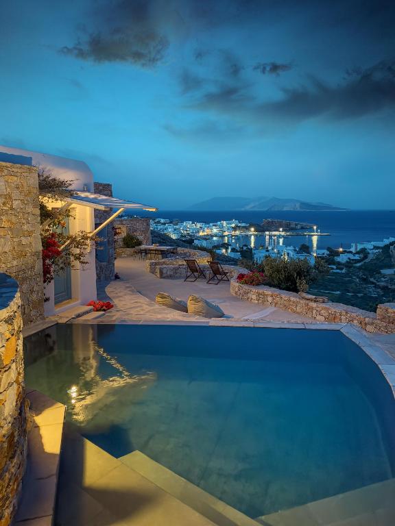 a swimming pool in a house with a view of the ocean at Villa Mikros Vorias in Karavostasi