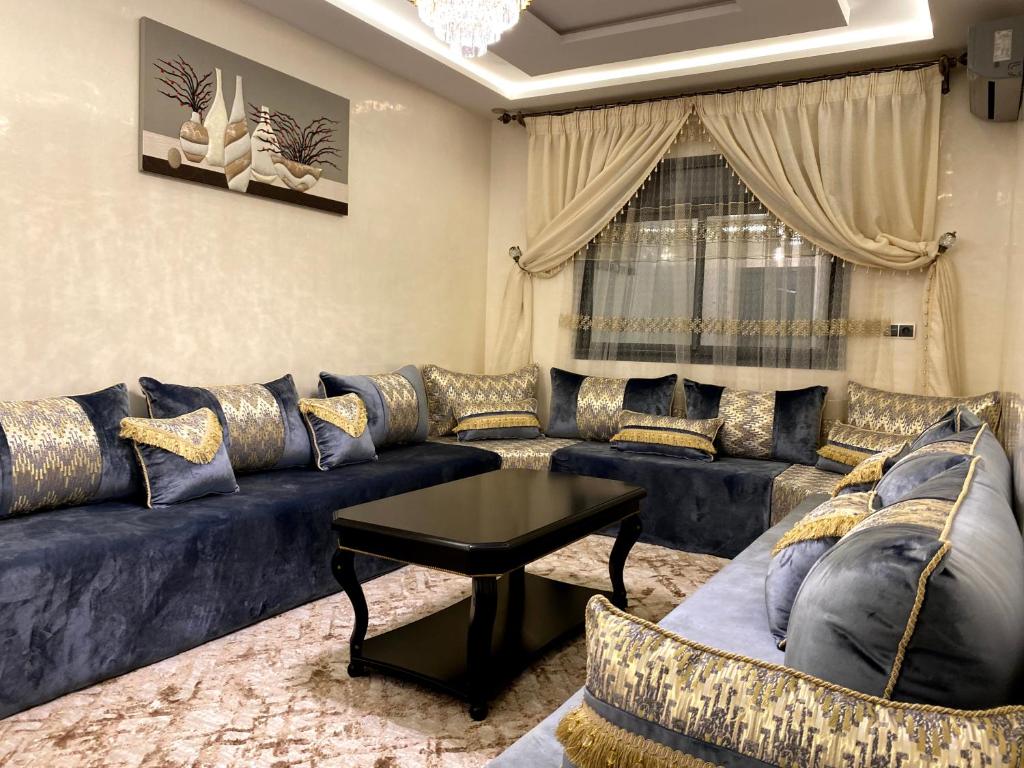 a living room with a blue couch and a table at Razan's Cozy Corner in Agadir