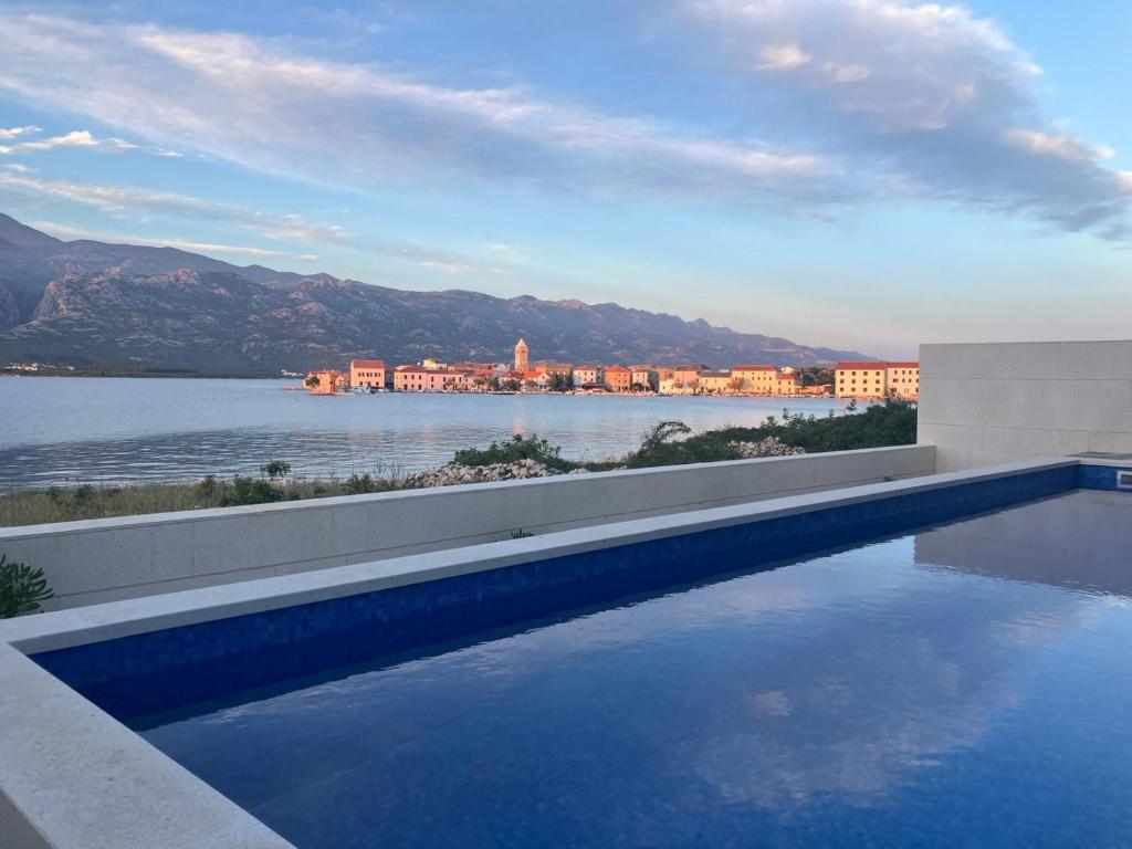 a swimming pool with a view of a body of water at Luxury beachfront apartment with private pool, Vinjerac in Vinjerac