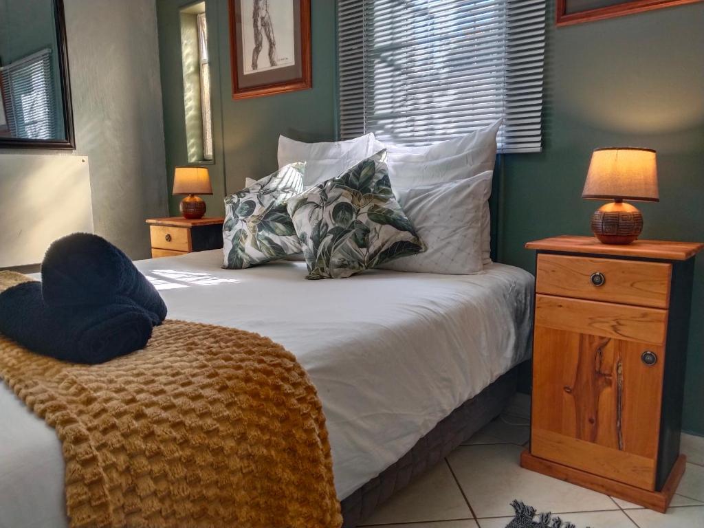 ein Schlafzimmer mit einem Bett mit weißen Laken und Kissen in der Unterkunft The Hilton Cottage in Hilton