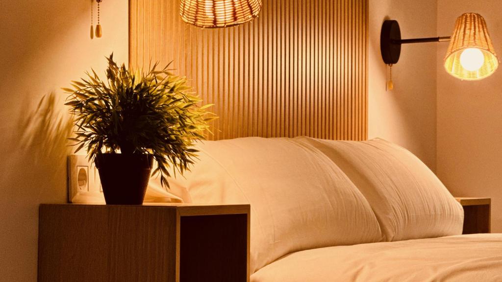 ein Schlafzimmer mit einem Bett mit einer Topfpflanze auf einem Tisch in der Unterkunft Click&Guest - Modern and Luxury Flat in Telde in Salinetas
