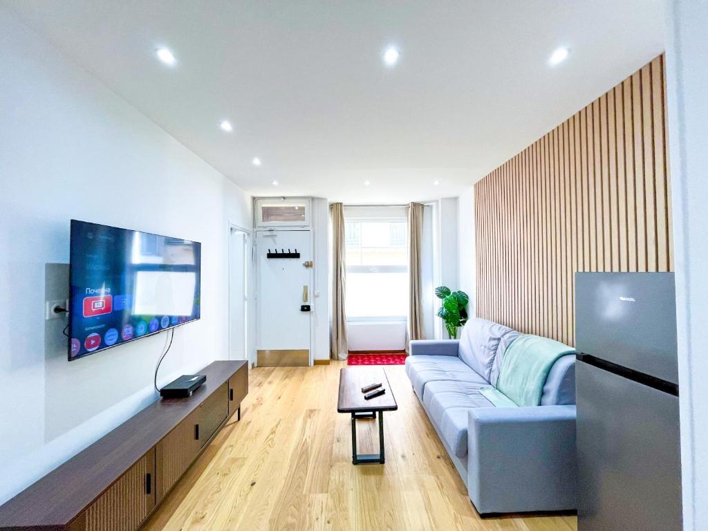un salon avec un canapé et une télévision à écran plat dans l'établissement Urban Flat 198 - Townhouse Basfroi, à Paris