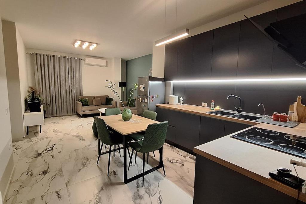 a kitchen with a table and chairs and a living room at White Palace in Vlorë