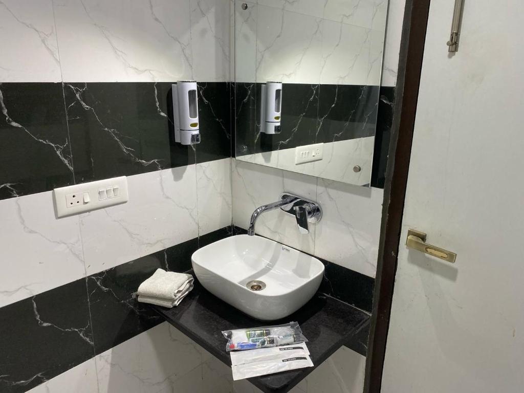 a bathroom with a sink and a mirror at Taj Comfort Inn in Agra