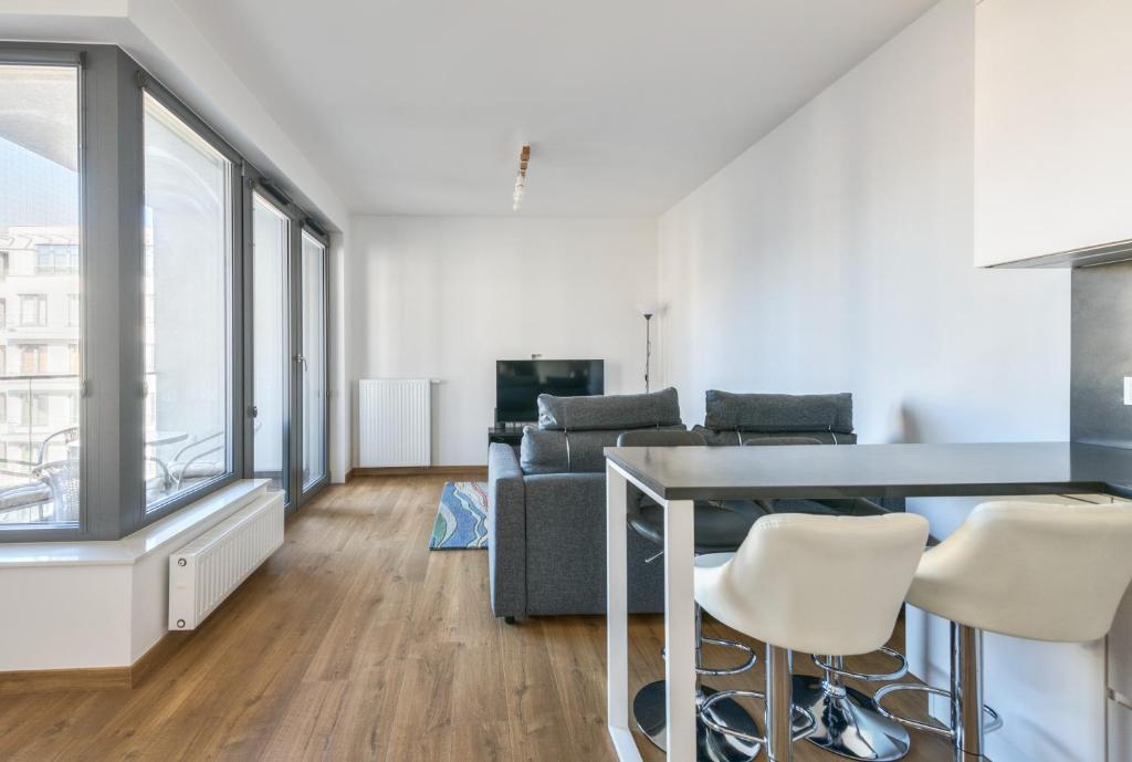 a living room with a table and chairs and a couch at Plac Unii by NorthSide Apartments in Gdynia
