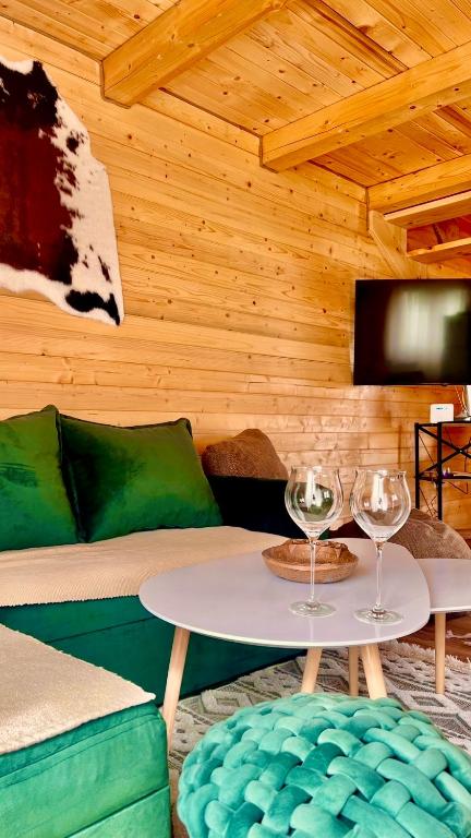 a room with a couch and a table with wine glasses at Alfa Omega Žabljak in Žabljak