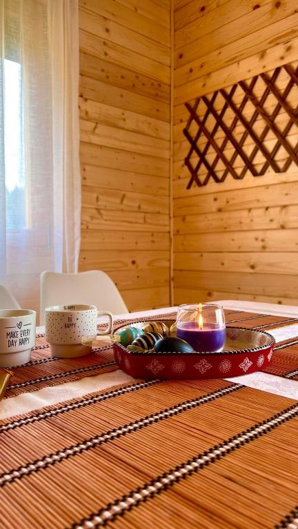 a table with a bowl of dishes and a candle at Alfa Omega Žabljak in Žabljak