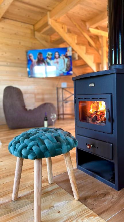 a stove in a room with a stool and a fireplace at Alfa Omega Žabljak in Žabljak