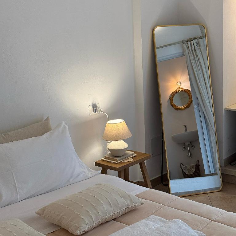 a bedroom with a white bed and a mirror at Dimora Santa Domenica in Scorrano