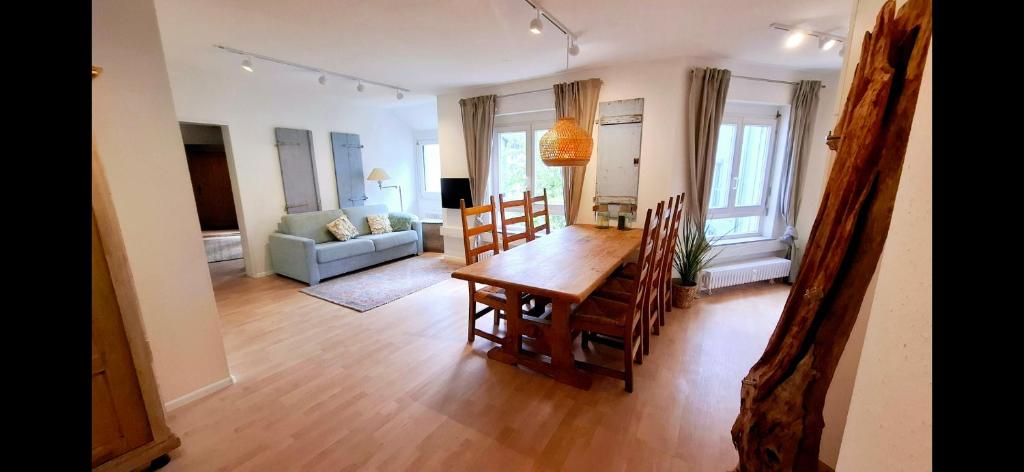 Wunderschöne und zentrumsnahe Ferienwohnung 75 qm في فريبورغ ام بريسغاو: غرفة طعام وغرفة معيشة مع طاولة وكراسي