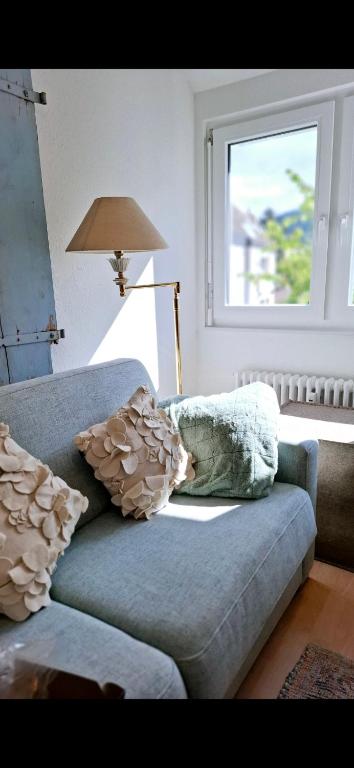 a living room with a couch with pillows and a window at Wunderschöne und zentrumsnahe Ferienwohnung 75 qm in Freiburg im Breisgau