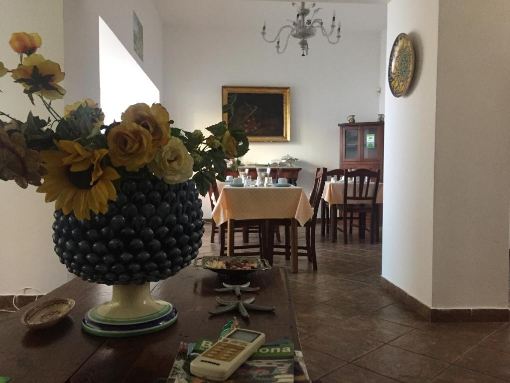 una sala de estar con un jarrón con flores sobre una mesa en Sciacca Bed and Breakfast Natoli, en Sciacca