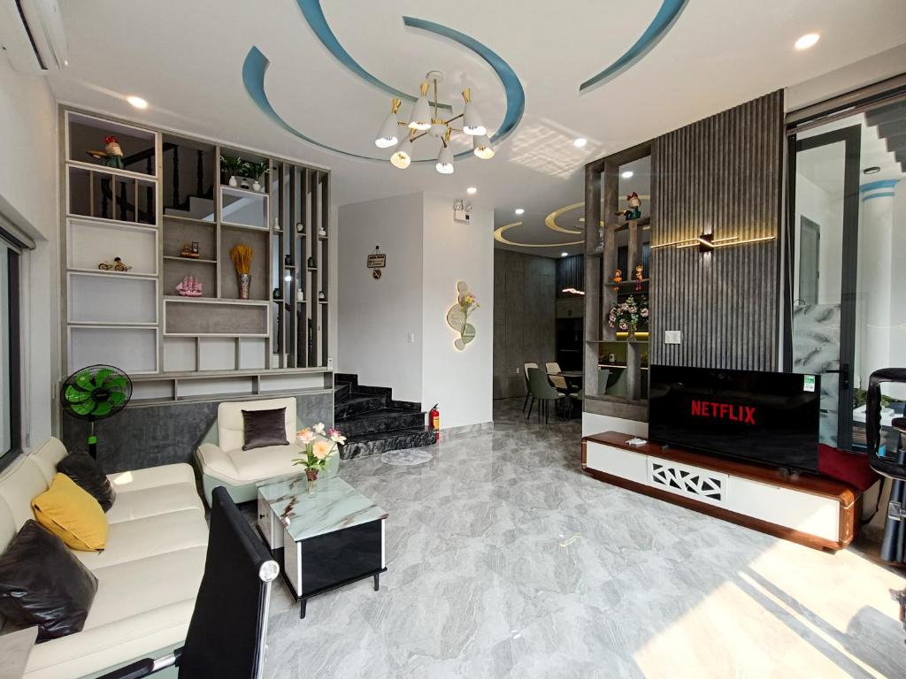 Una sala de estar con un sofá y un televisor. en Aroma Mỹ Khê 2BR 3WC Jacuzzi 650m to My Khe beach, en Da Nang