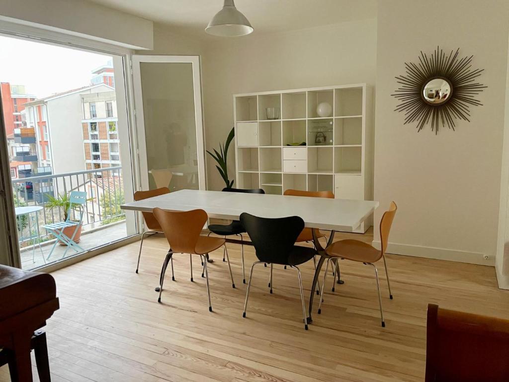 une salle à manger avec une table et des chaises blanches dans l'établissement Casual, à Toulouse