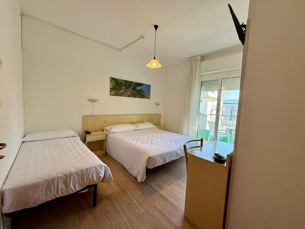 a room with two beds and a window at Hotel Palme Park & Beach included in Lido di Jesolo