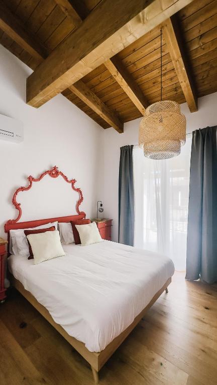 a bedroom with a large white bed with blue curtains at La Bianca Dimora B&B in Gioia del Colle