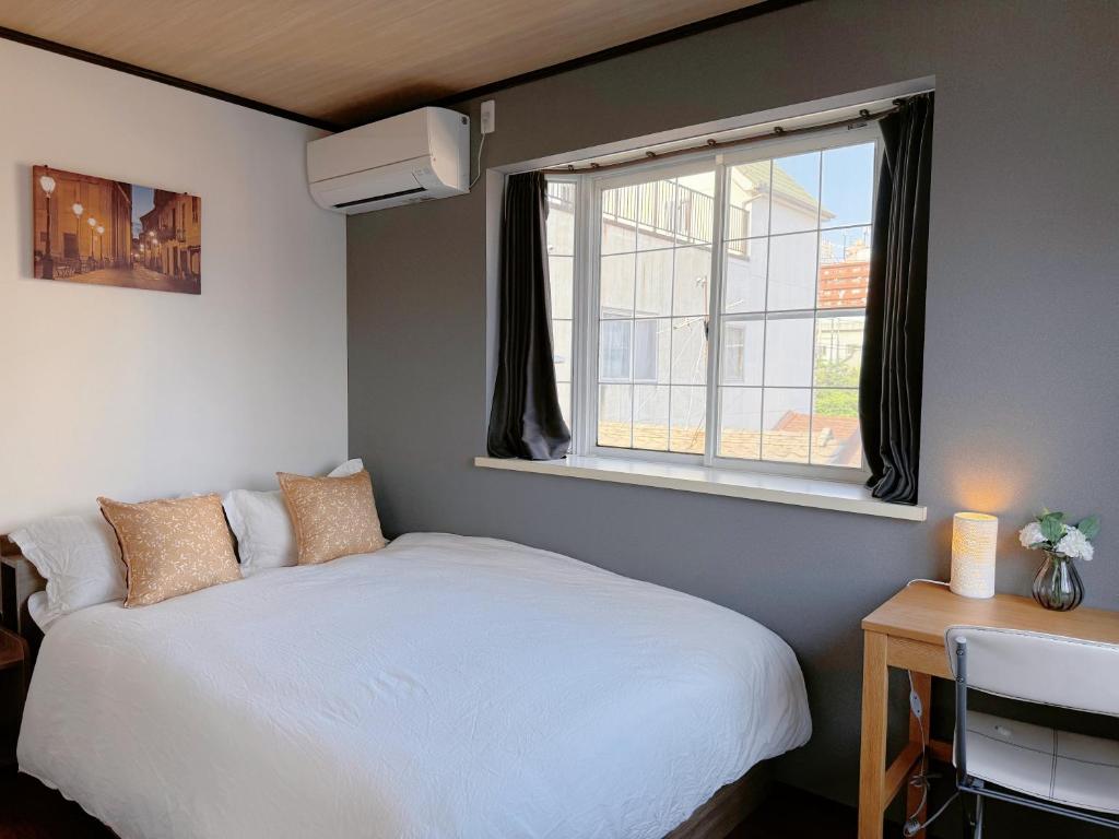 a bedroom with a white bed and a window at NewDayHouse日式洋房独栋最多住10人 新今宫站近温泉通天阁天王寺 机场直达 半小时到世博会 in Osaka