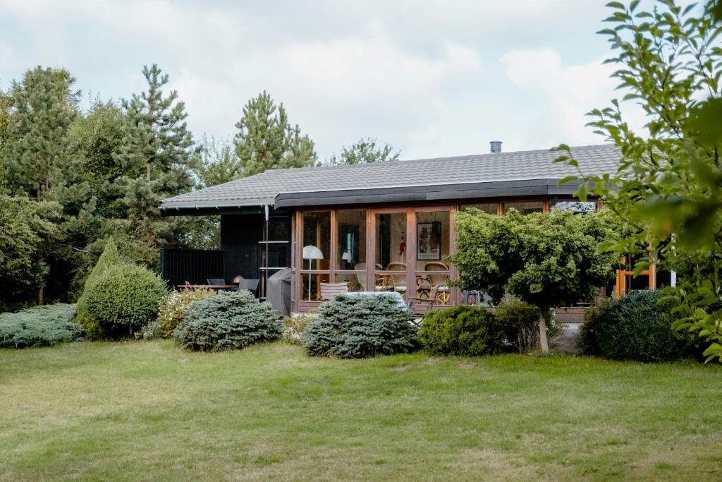 a house with a garden in front of it at Stay In Hilly Landscape With Sea View in Asnæs