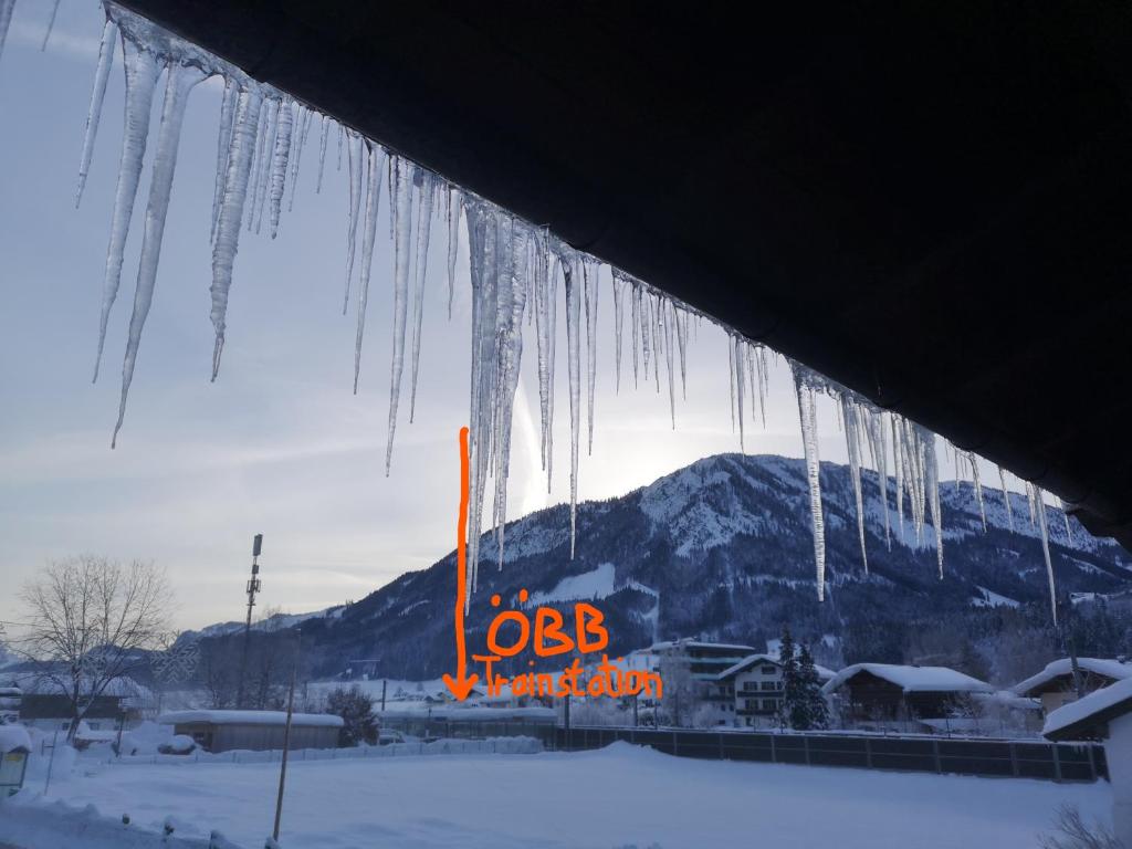 a bunch of icicles hanging from a building in the snow at Alte Hof in Brixen im Thale