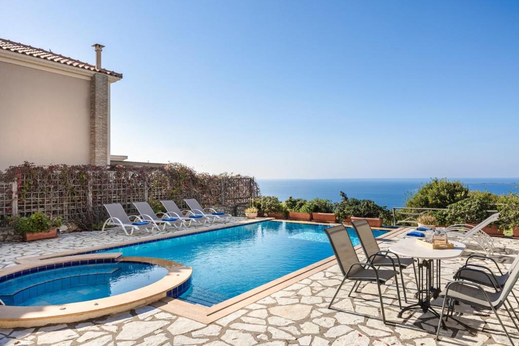 a villa with a swimming pool and chairs at Lassi Seaview Villa Private Pool Villa Efrosini Short Walk To Resort Centre in Kefallonia