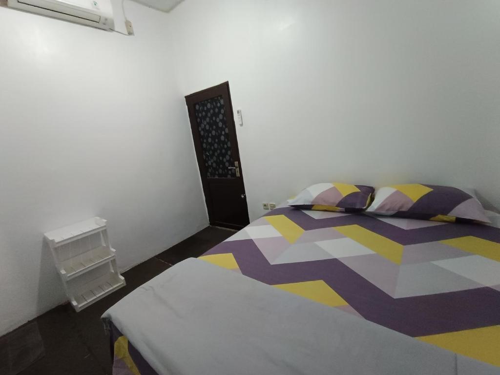 Postel nebo postele na pokoji v ubytování Penginapan Violet Doorz Syariah