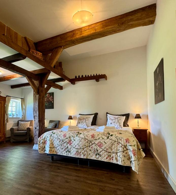 a bedroom with a bed in a room with wooden ceilings at Hofstede de Rieke Smit in Wilsum