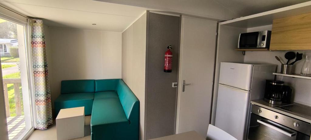 a small kitchen with a blue bench and a refrigerator at Houlgate-154- Mobilhome cosy 4 personnes Camping 5 étoiles in Houlgate