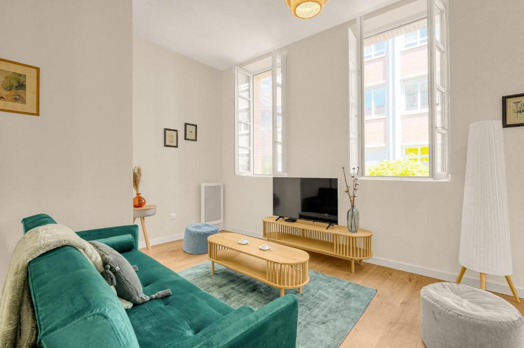 - un salon avec un canapé vert et une télévision dans l'établissement Bloom - 12min à pied du Capitole, à Toulouse