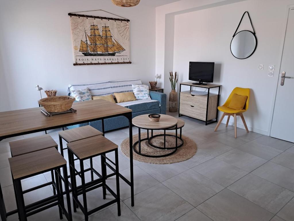 un salon avec une table et un canapé dans l'établissement Studio tout neuf, tout équipé, à 2 pas de l'océan, à Biscarrosse